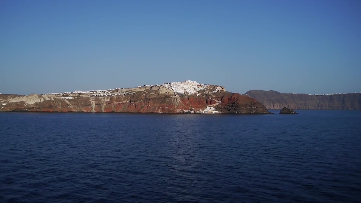 Mar azul e costa vulcânica de Santorini vistos a partir da água
